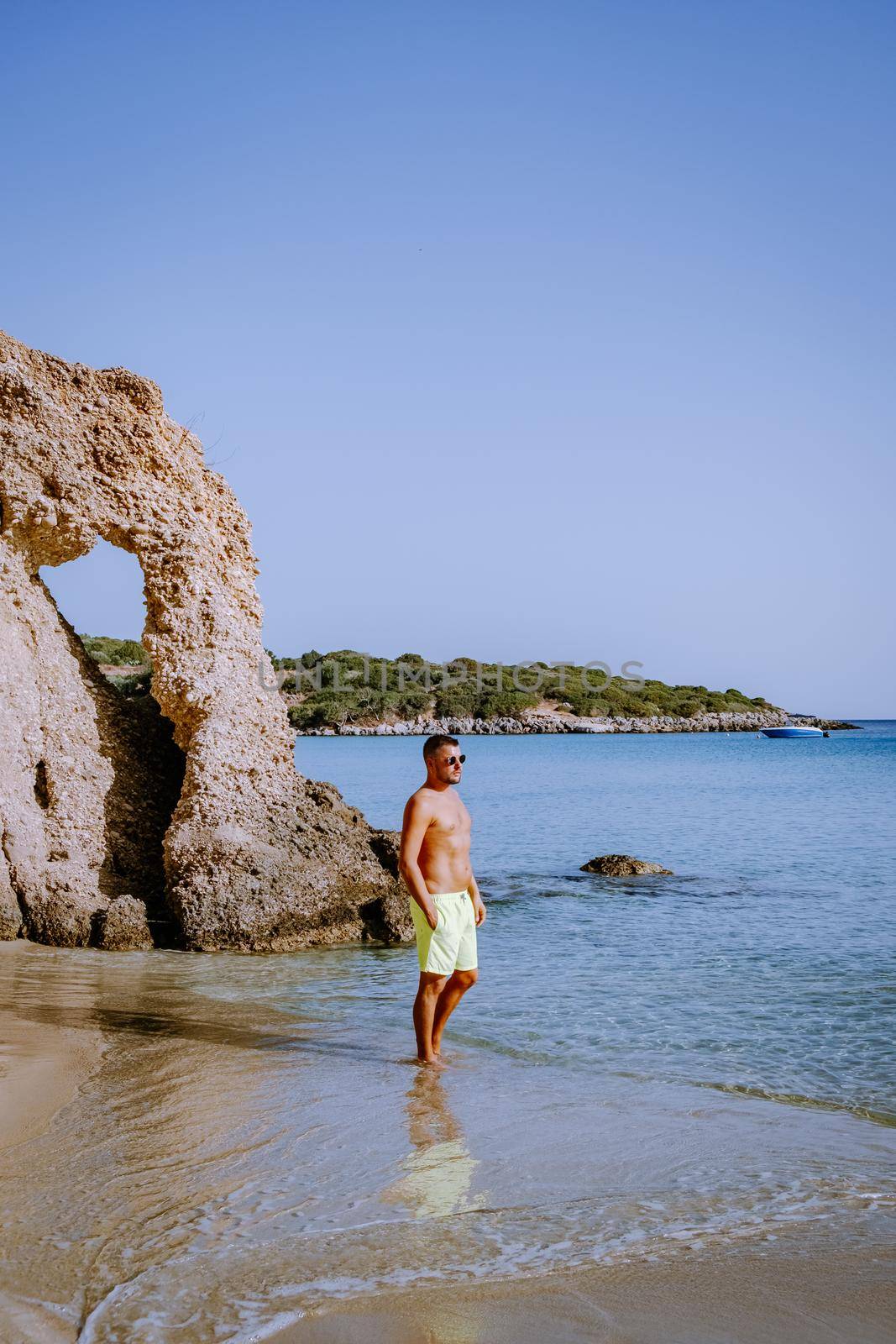 Tropical beach of Voulisma beach, Istron, Crete, Greece Europe, young guy in swim short on the beach