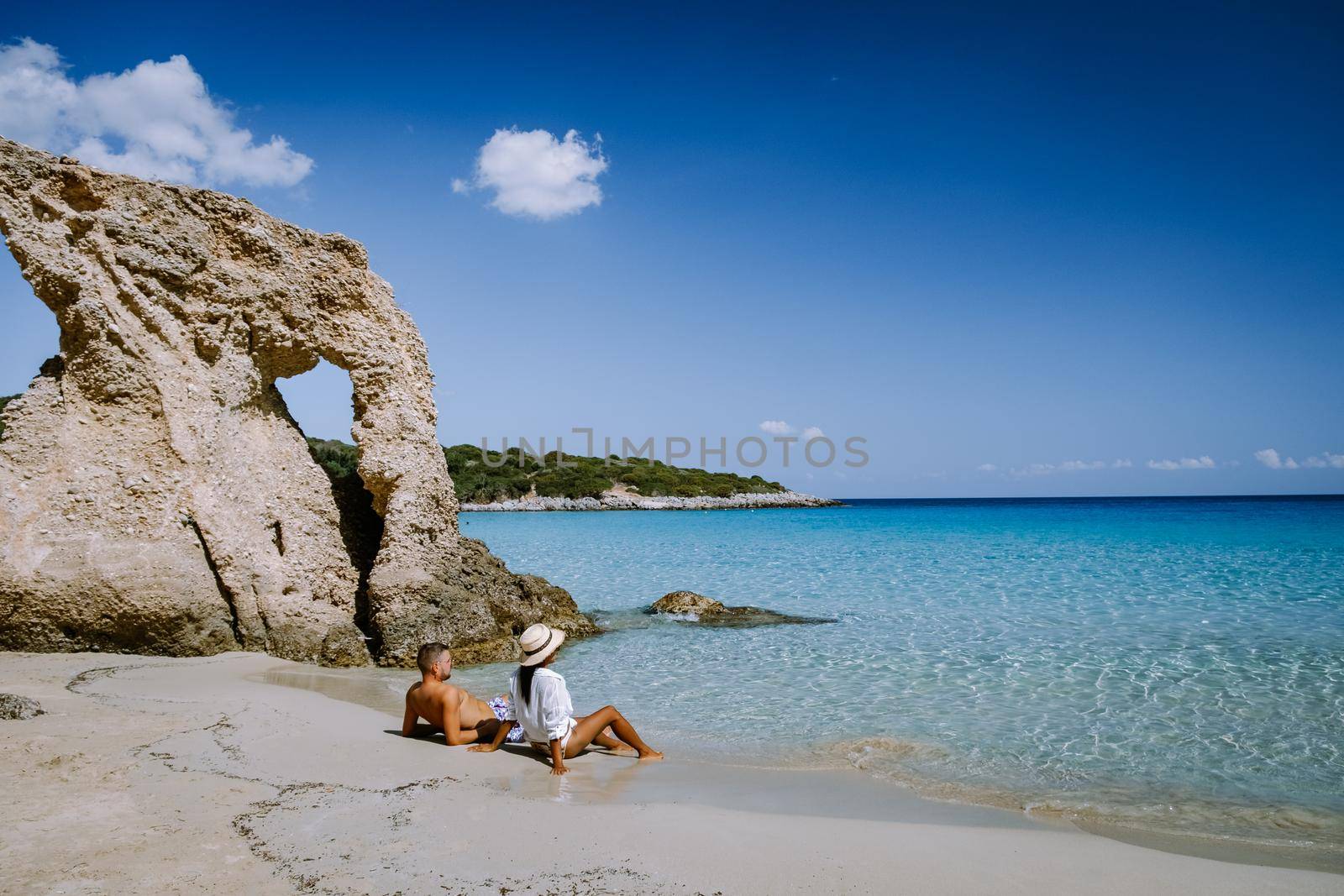 Young happy couple on seashore Crete Greece, men, and woman Voulisma beach Crete Greece. Europe