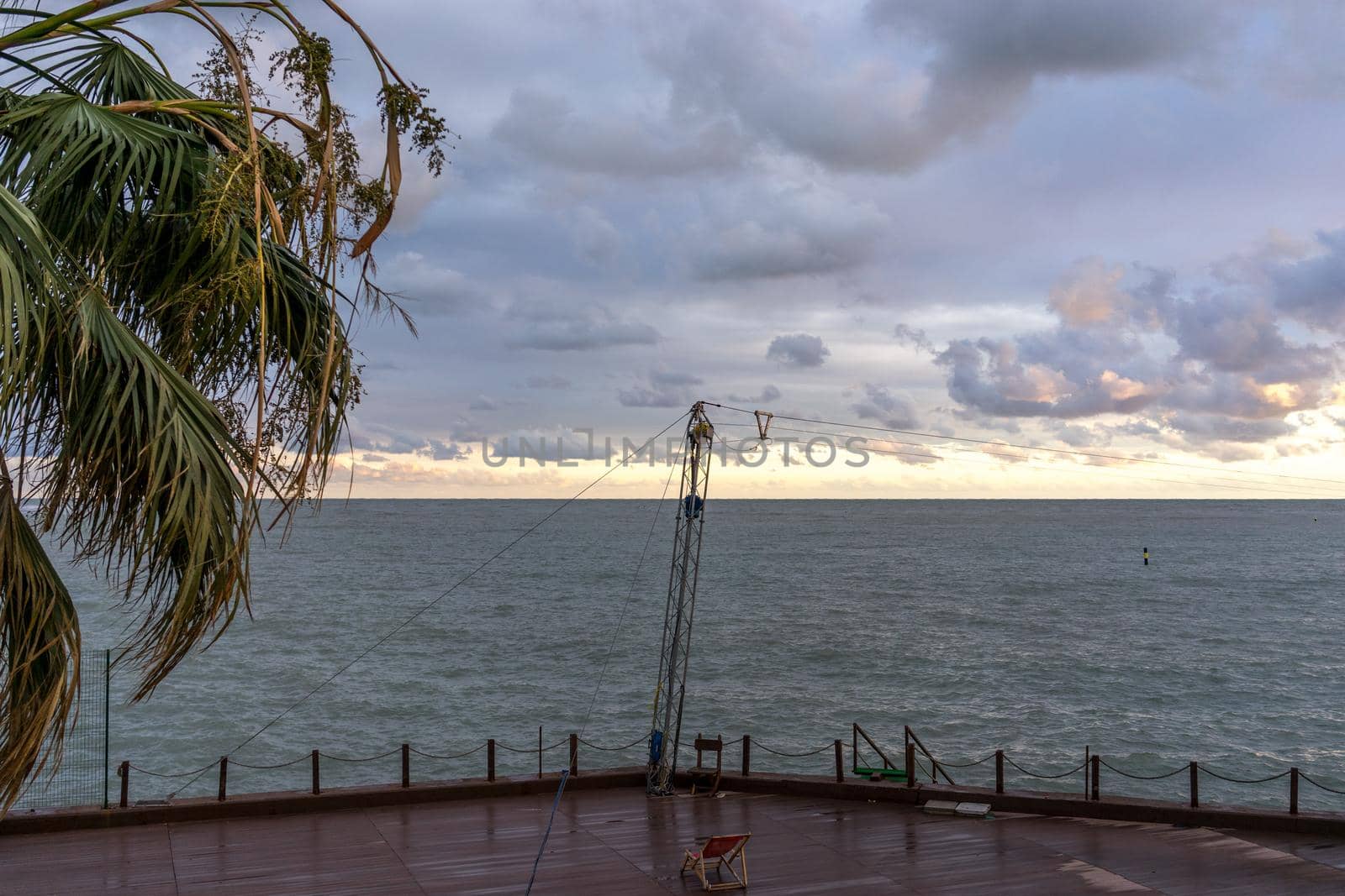 Sochi, Russia. Deserted promenade overlooking the sea and a lonely palm tree in the autumn evening.