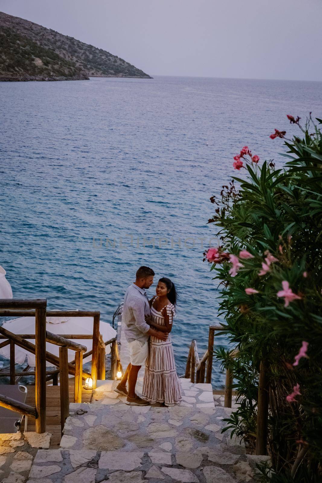 couple men and woman watching sunset over the ocean of Crete Greece Europe