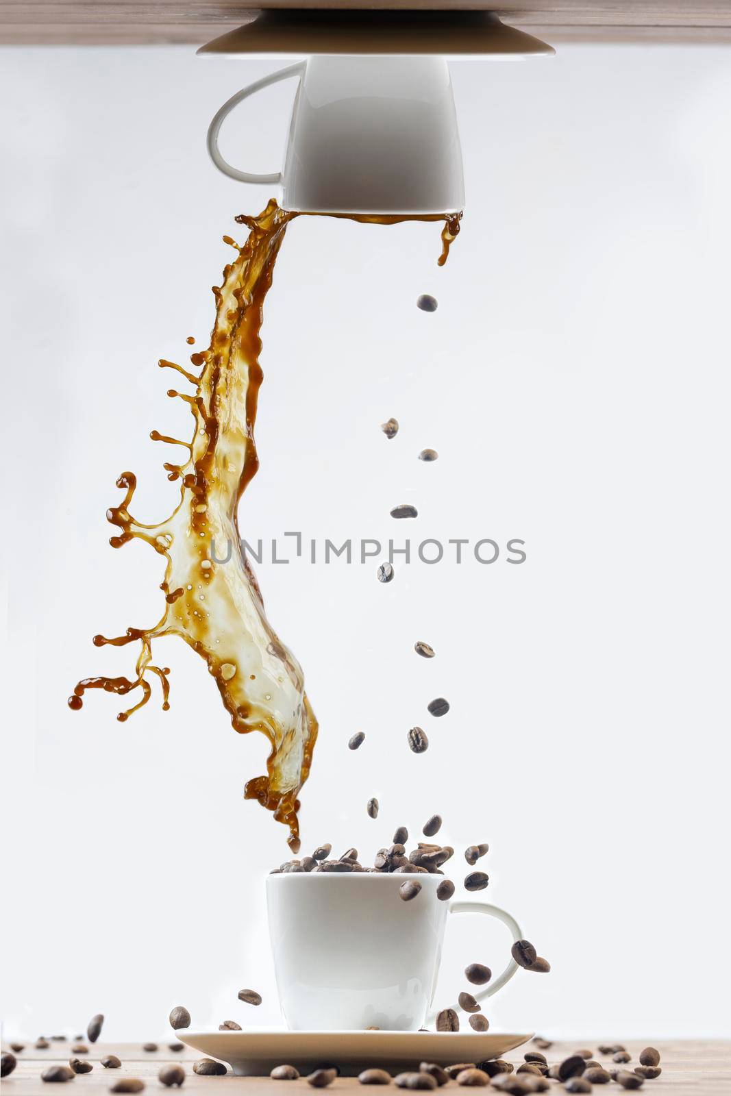 Splashing of coffee in white cup and falling coffee beans on white background by sashokddt