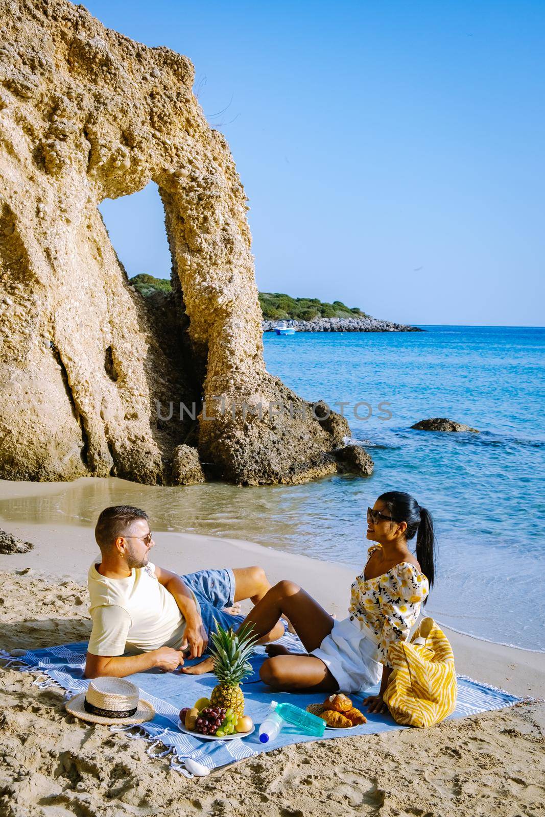 Tropical beach of Voulisma beach, Istron, Crete, Greece Europe, couple men and woman mid age on the beach during vacation in the summer of Europe