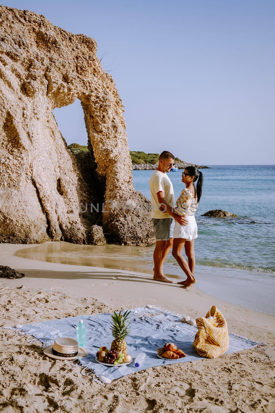 Tropical beach of Voulisma beach, Istron, Crete, Greece Europe, couple men and woman mid age on the beach during vacation in the summer of Europe