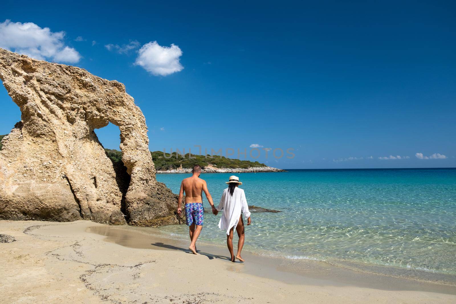 Young happy couple on seashore Crete Greece, men, and woman Voulisma beach Crete Greece. Europe