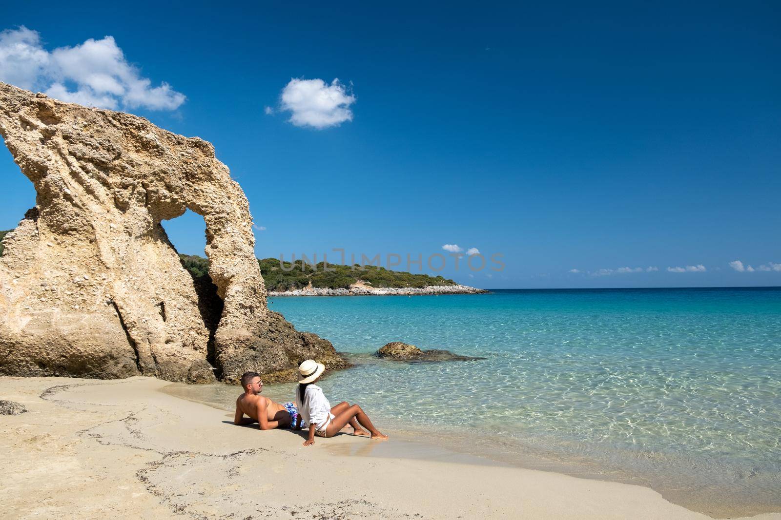 Tropical beach of Voulisma beach, Istron, Crete, Greece Europe, couple men and woman mid age on the beach during vacation in the summer of Europe