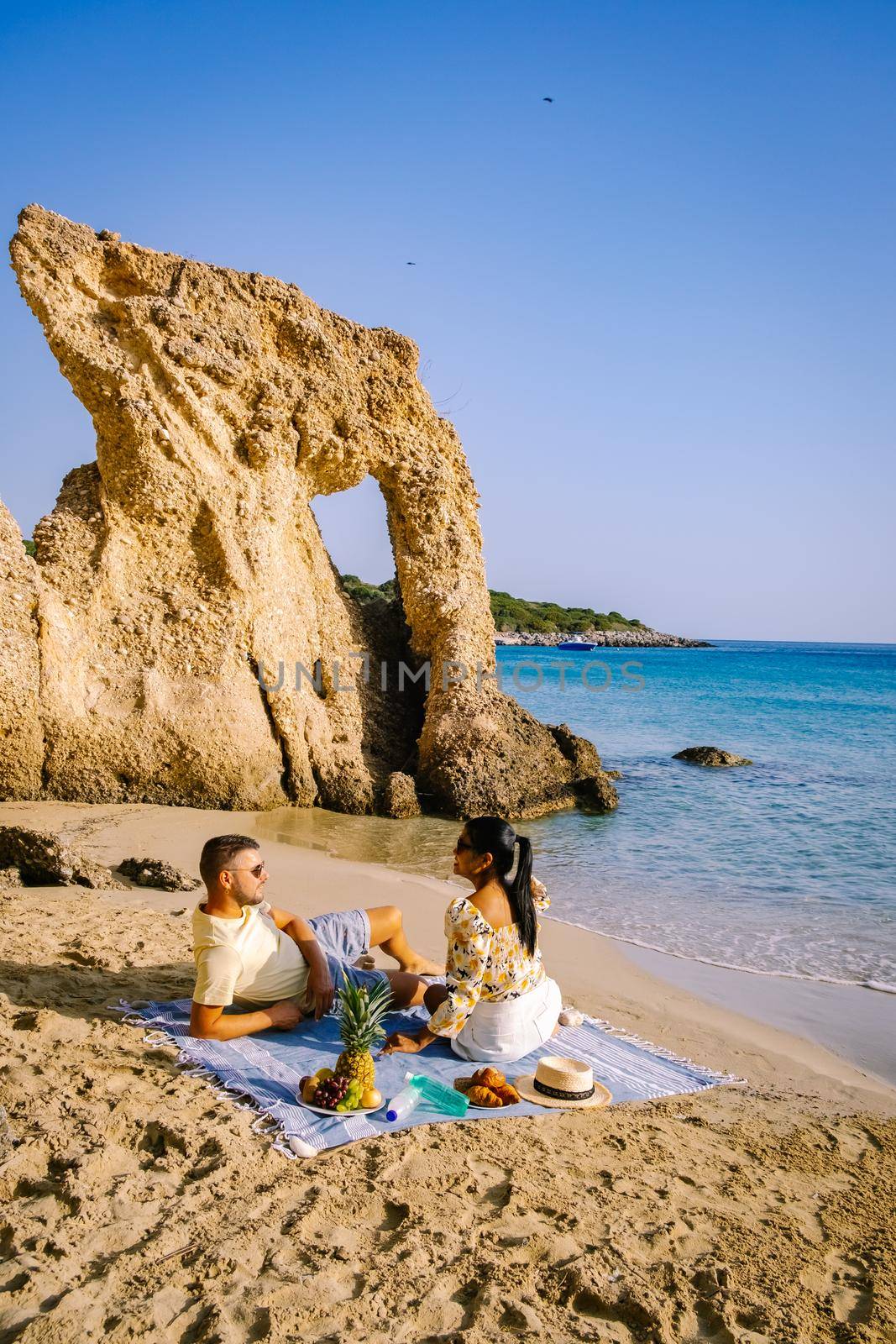 Tropical beach of Voulisma beach, Istron, Crete, Greece Europe, couple men and woman mid age on the beach during vacation in the summer of Europe