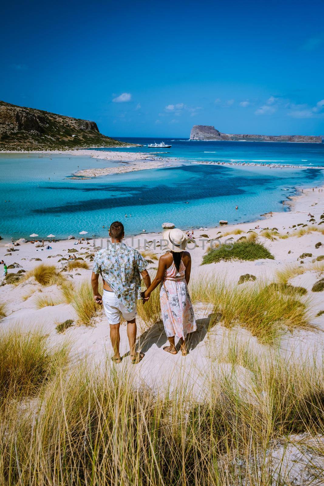 Crete Greece, Balos lagoon on Crete island, Greece. Tourists relax and bath in crystal clear water of Balos beach. Greece, couple men and woman visiting the beach