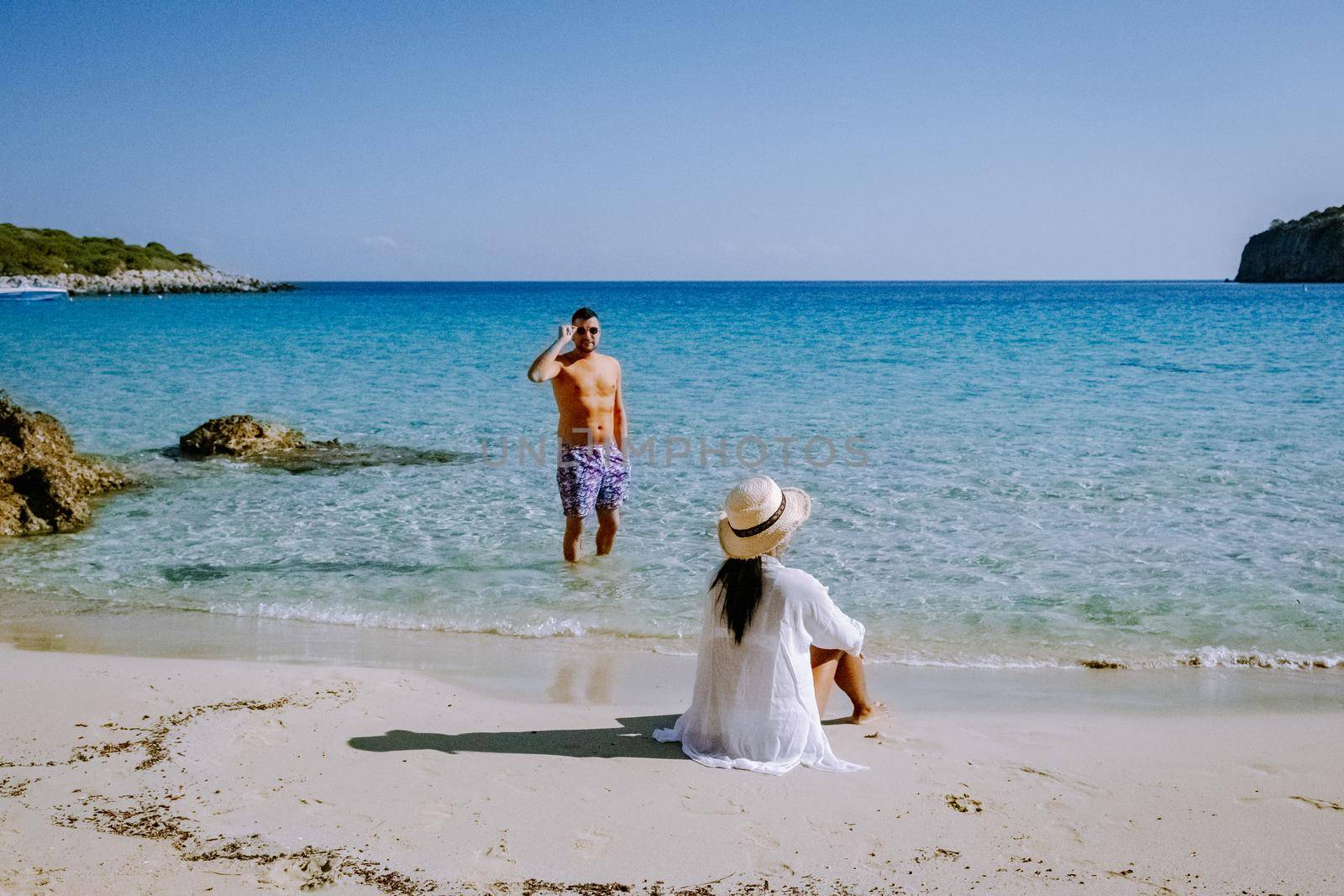 Young happy couple on seashore Crete Greece, men, and woman Voulisma beach Crete Greece. Europe