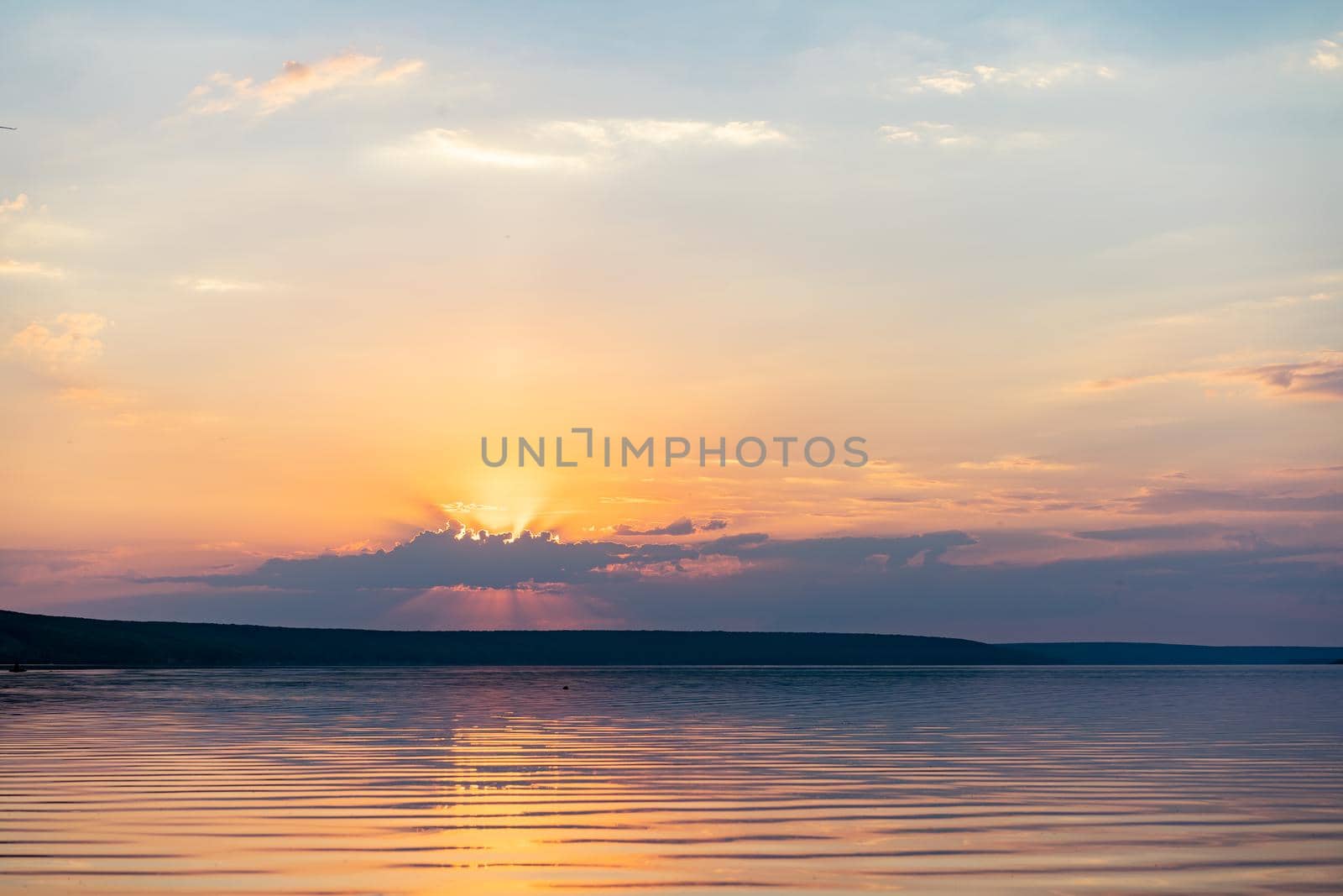 Dramatic sunset over sea water with cloudy sky Golden colored nature background with calm water