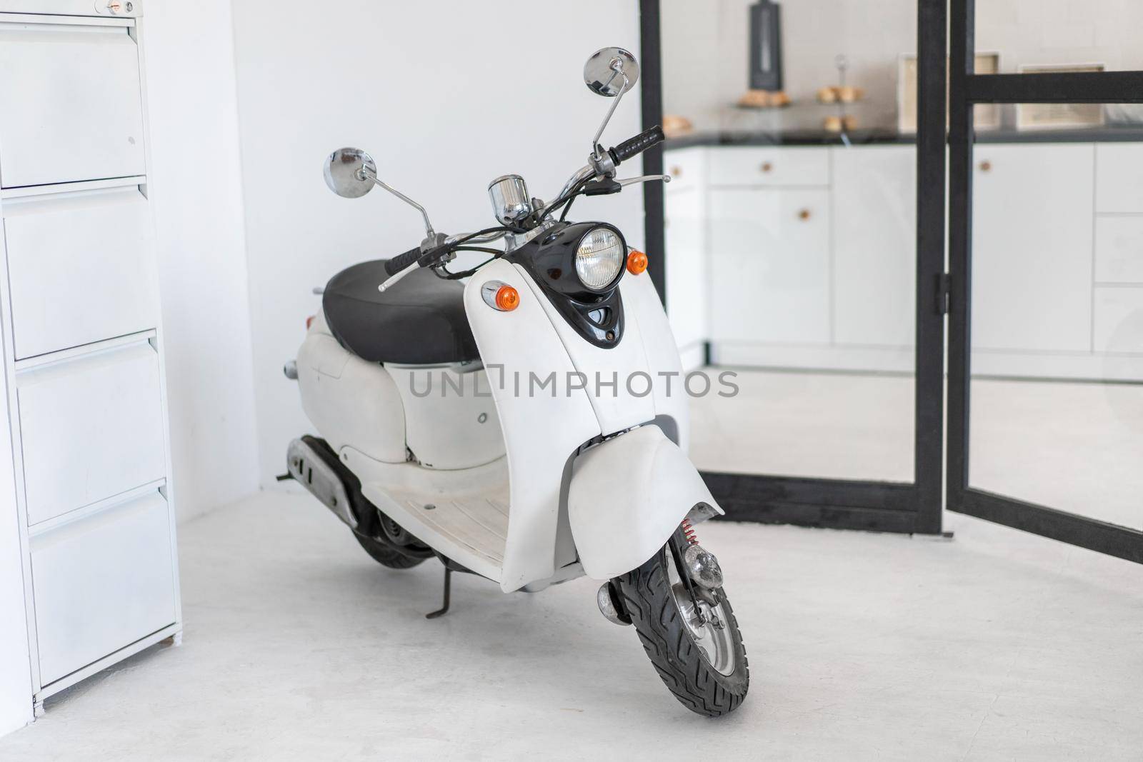 White retro moped standing indoor Vintage scooter stands indoors as interior decoration Nobody