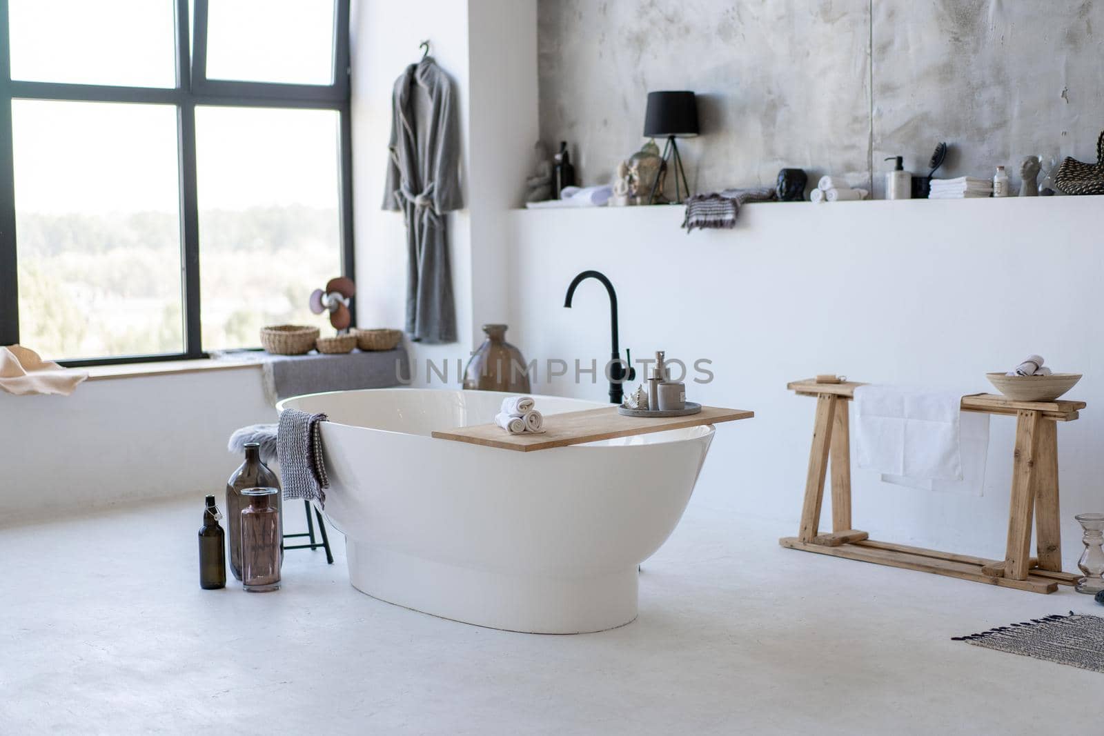 Modern vintage white bathroom near big window with many accessories