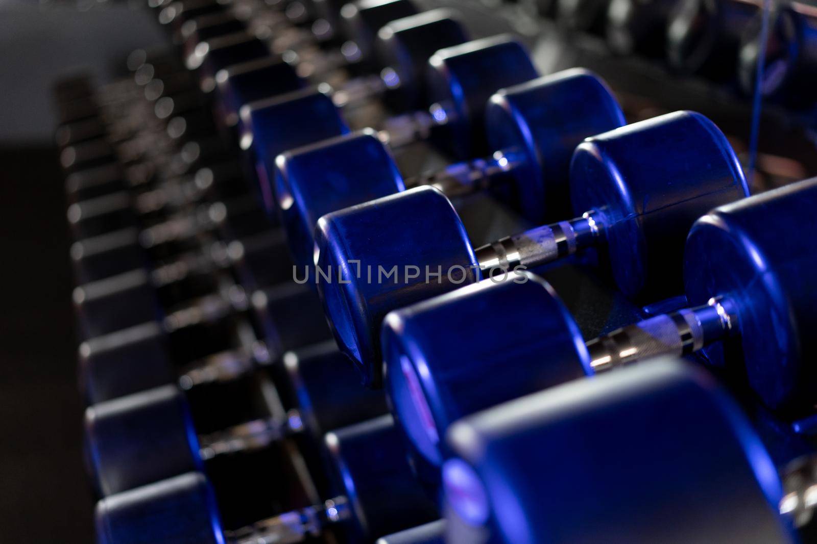 Dumbbells in a row at gym Dark toned Healthy lifestyle fitness concept