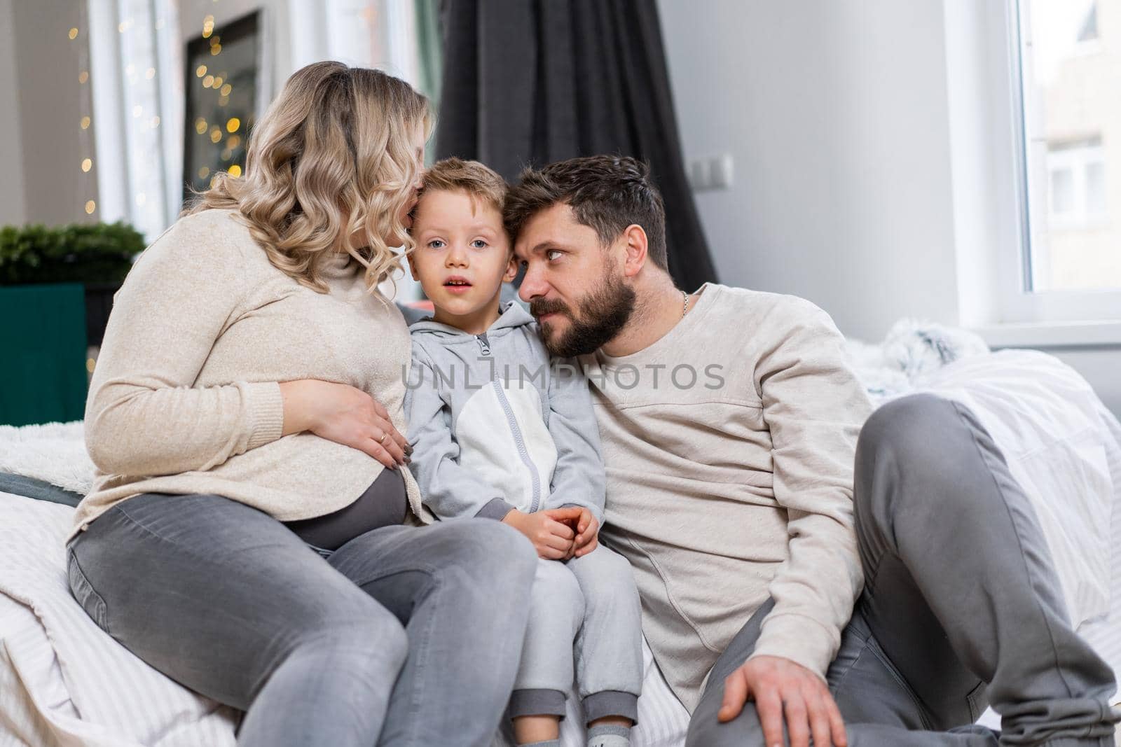 Happy family concept Mother father and little son have fun at home Caucasian family indoors Pregnant mom beard dad and funny little boy