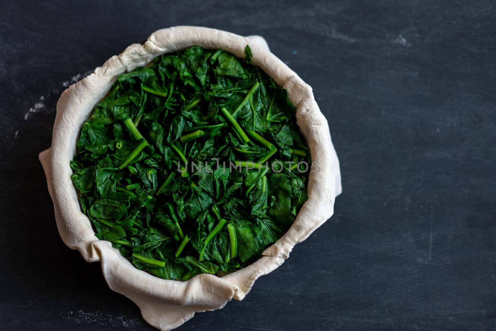 raw spinach pie preparation Standing wooden table background Copy space for text