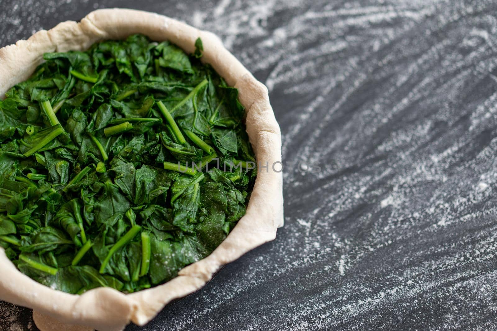 raw spinach pie preparation Standing wooden table background Copy space for text