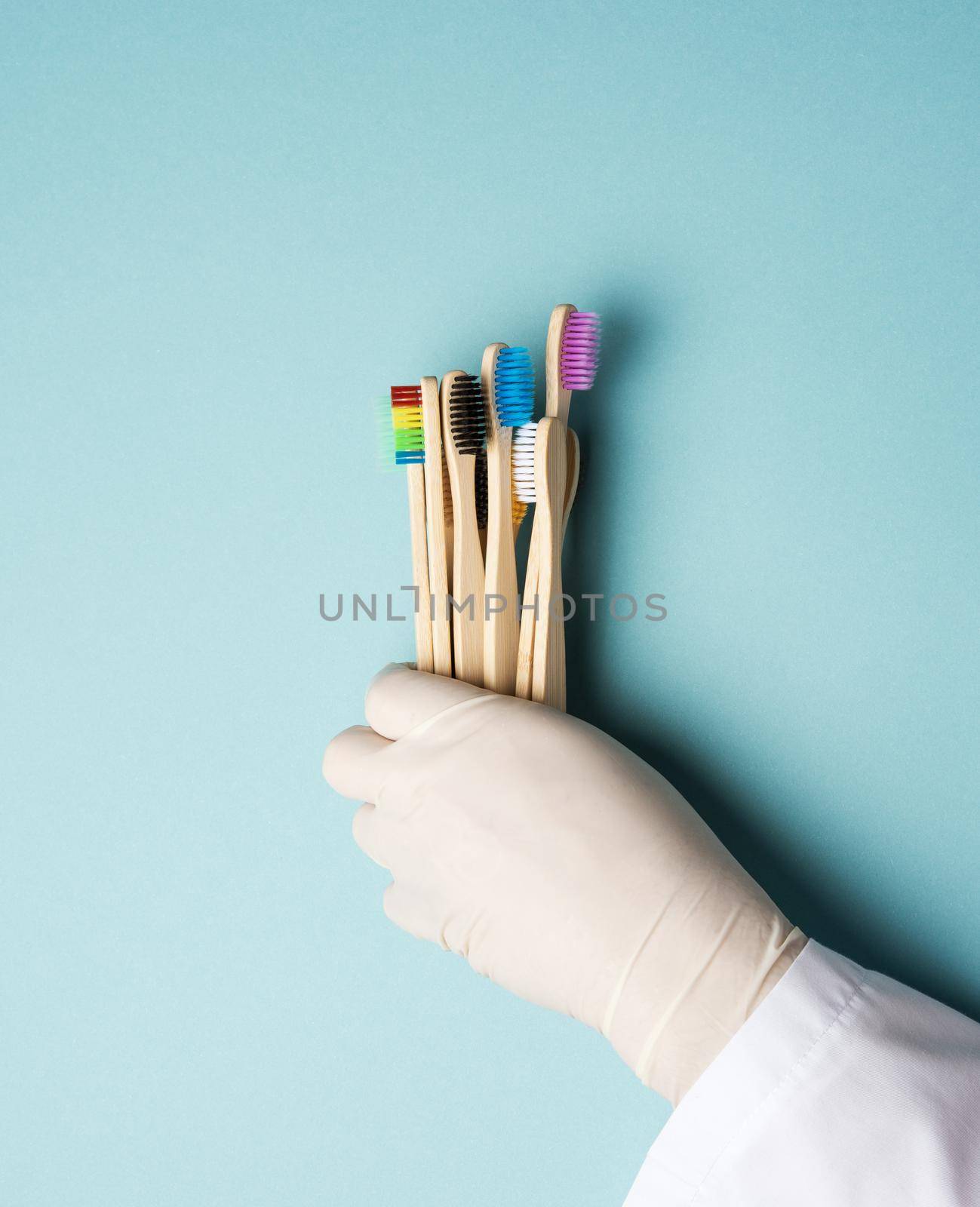 multicolored wooden toothbrushes on a blue background, plastic rejection concept, zero waste