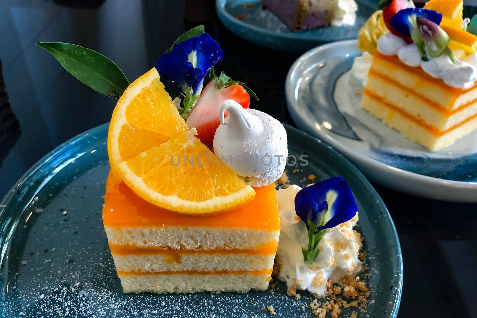 Orange cake with orange topping on plate ready to eat