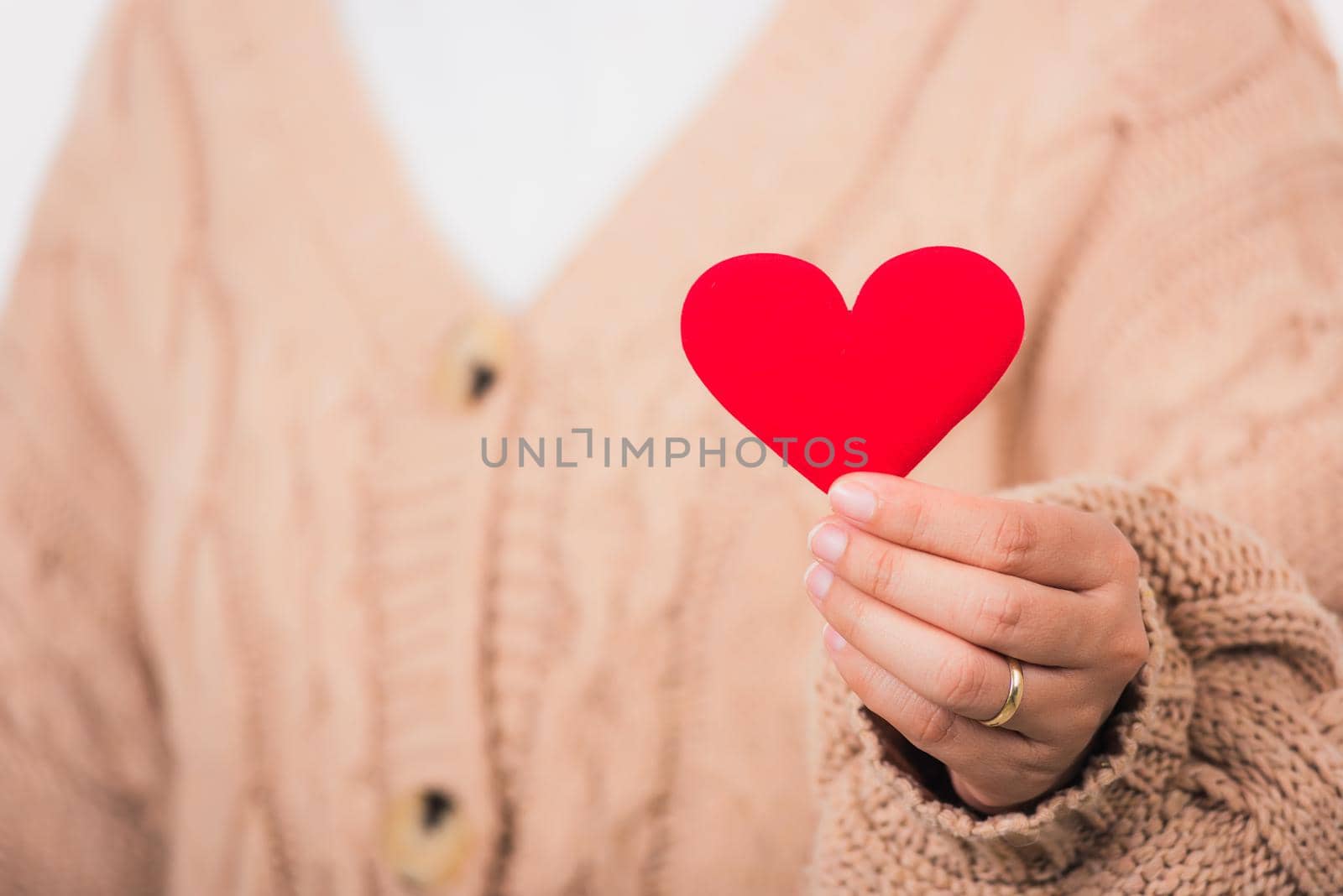 Female beauty hands holding modern a red heart by Sorapop