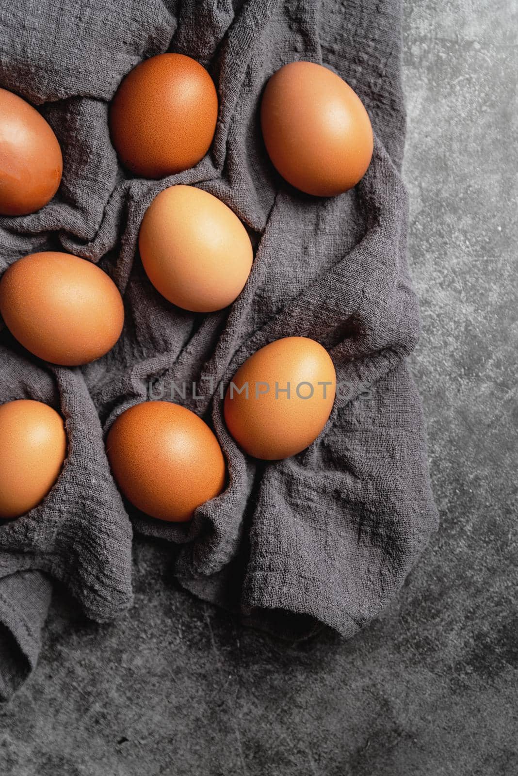 brown chicken eggs on dark gray fabric top view flat lay