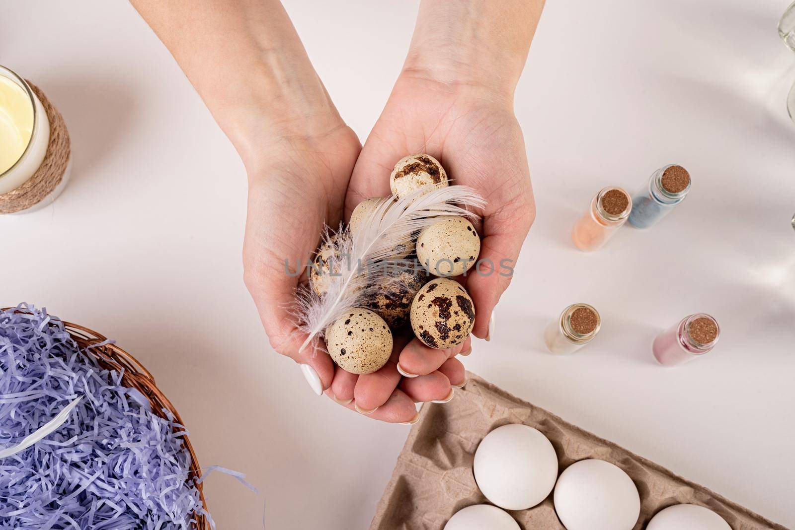 Easter holiday concept. Female hands holding quail eggs redy for coloring