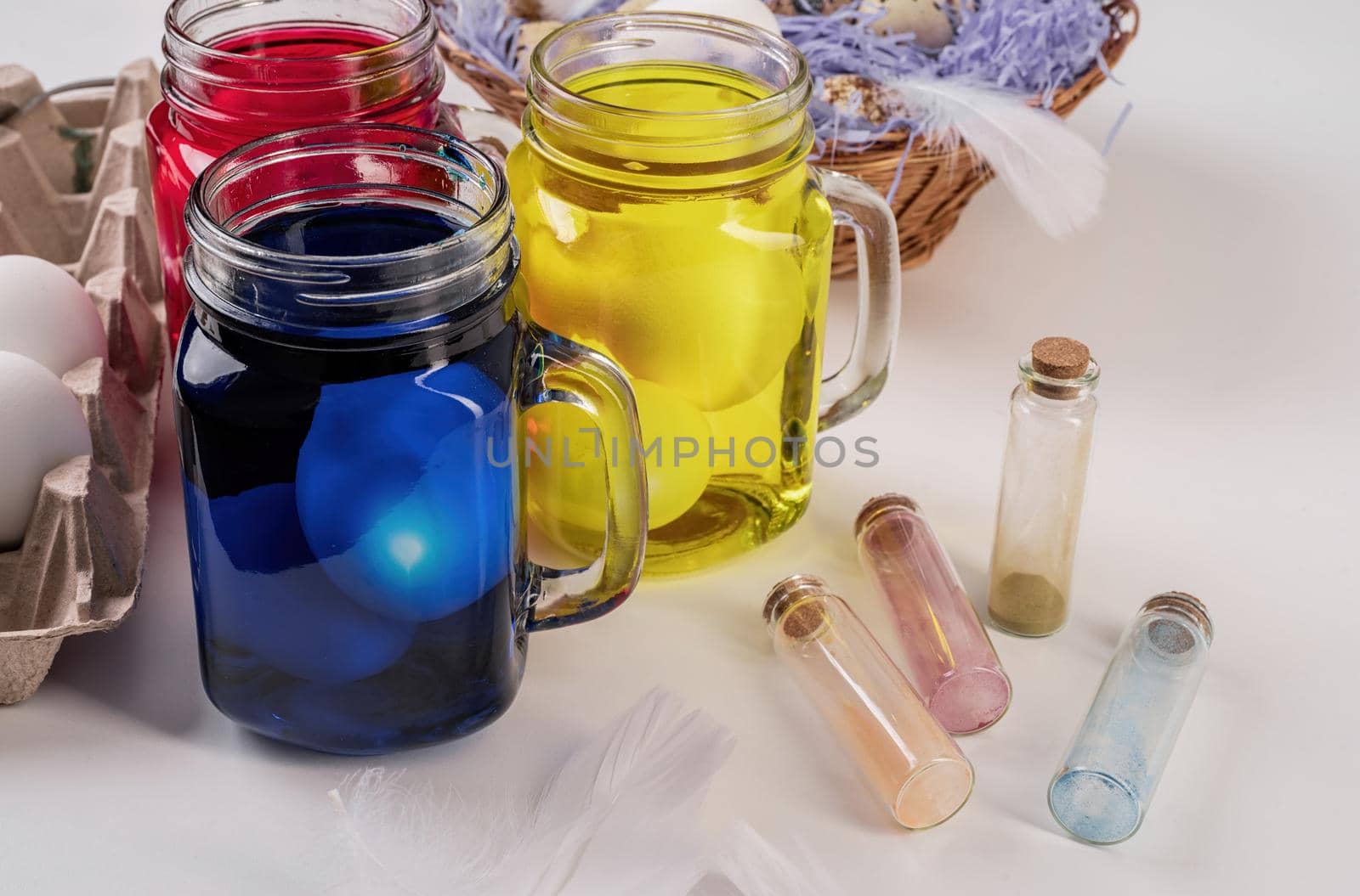 mason jars with colorful eggs inside on the table front view by Desperada