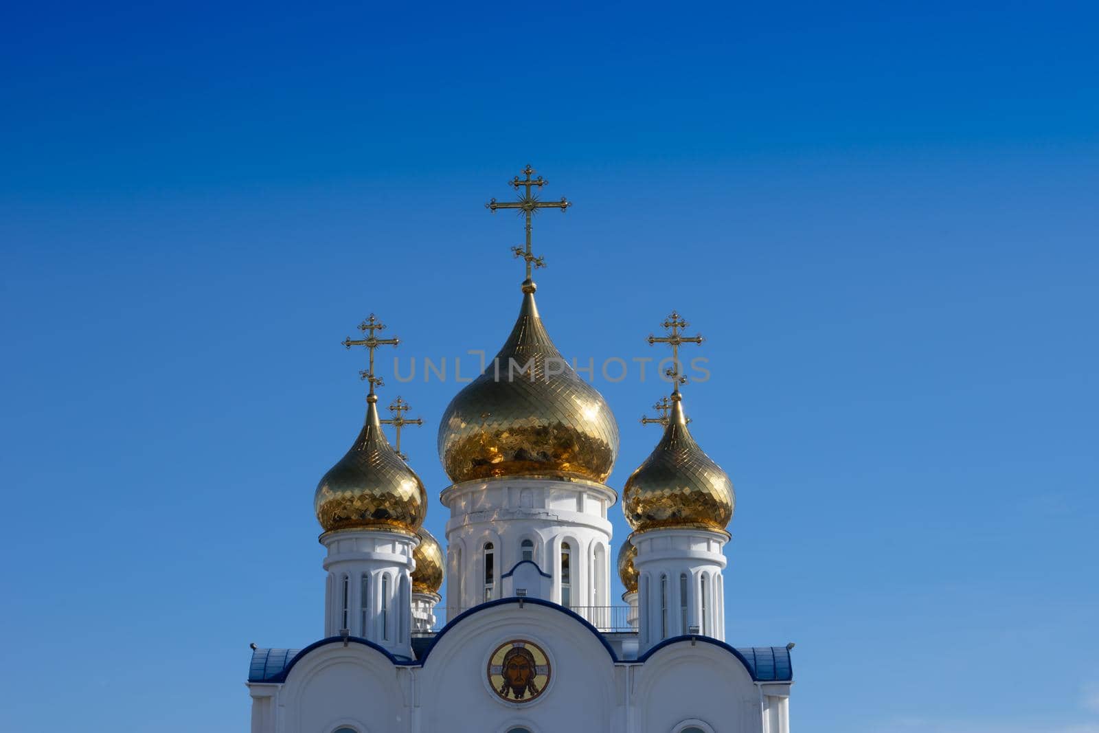 Golden domes of the Church of St. Nicholas against the blue sky. Petropavlovsk-Kamchatsky, Russia.
