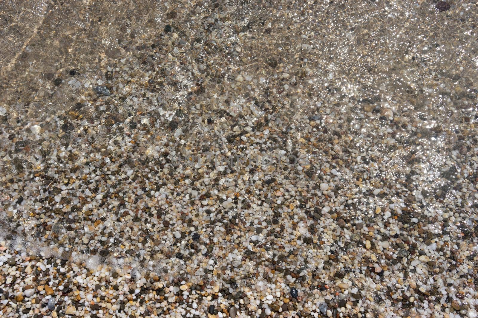 Natural background with water and rocks on the shore.