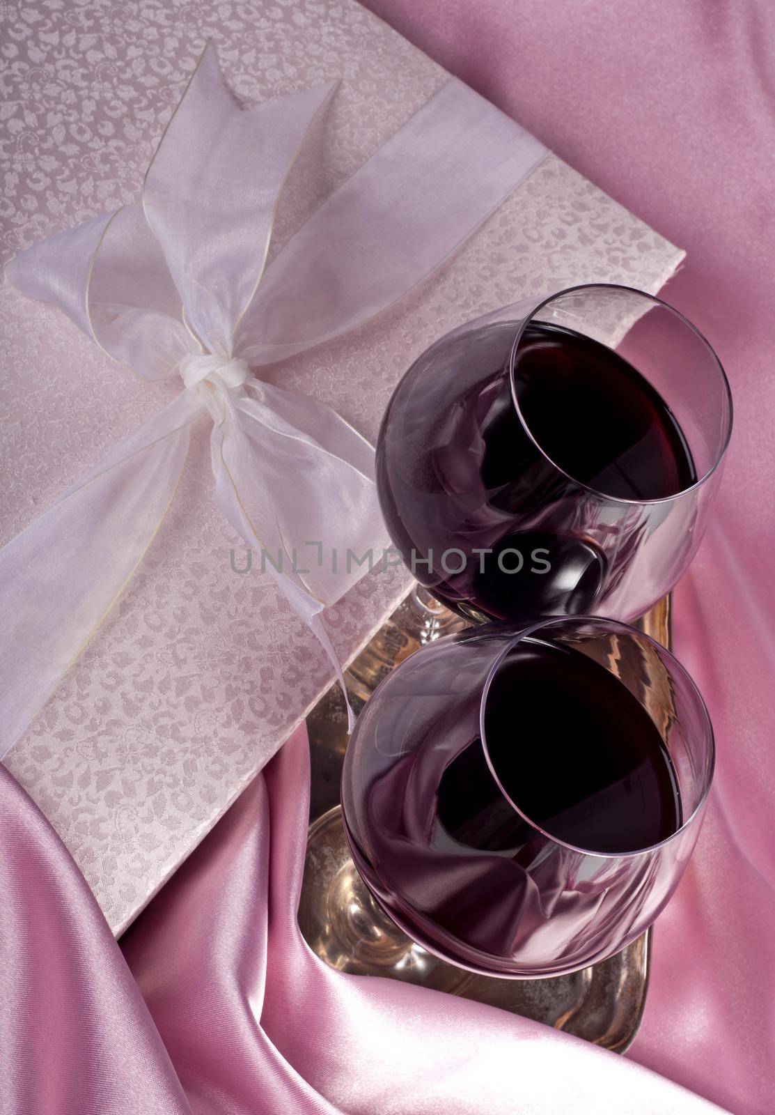 Valentine's Day. Gift box, flowers, glasses with wine on the pink color background by aprilphoto