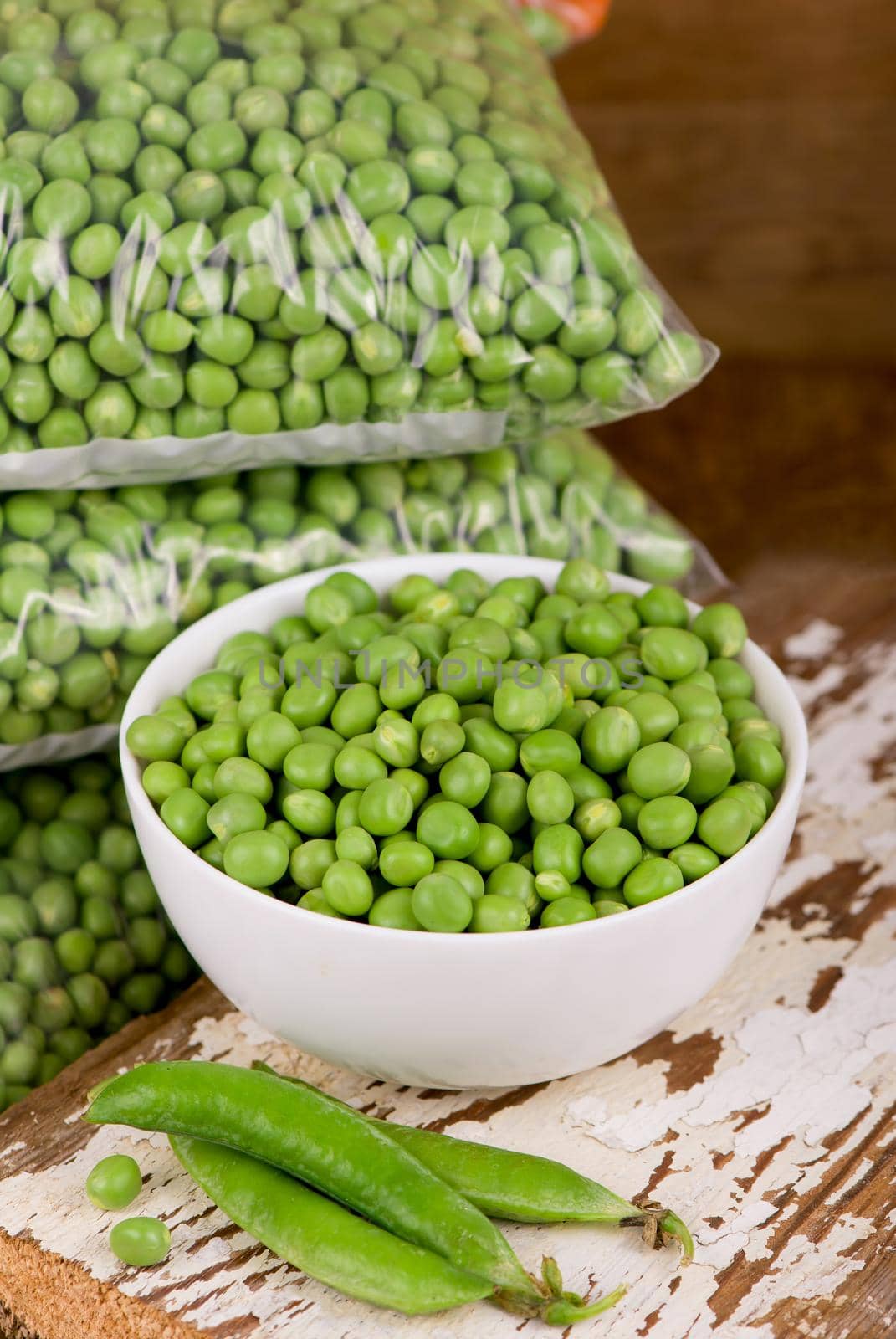 fresh green pea in bowl on wooden background.