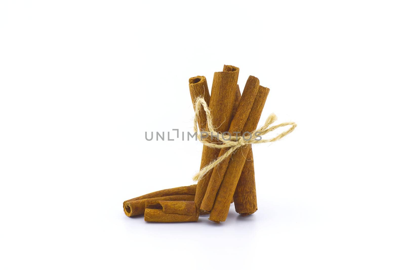 Cinnamon sticks bundle tied with jute string isolated on white background