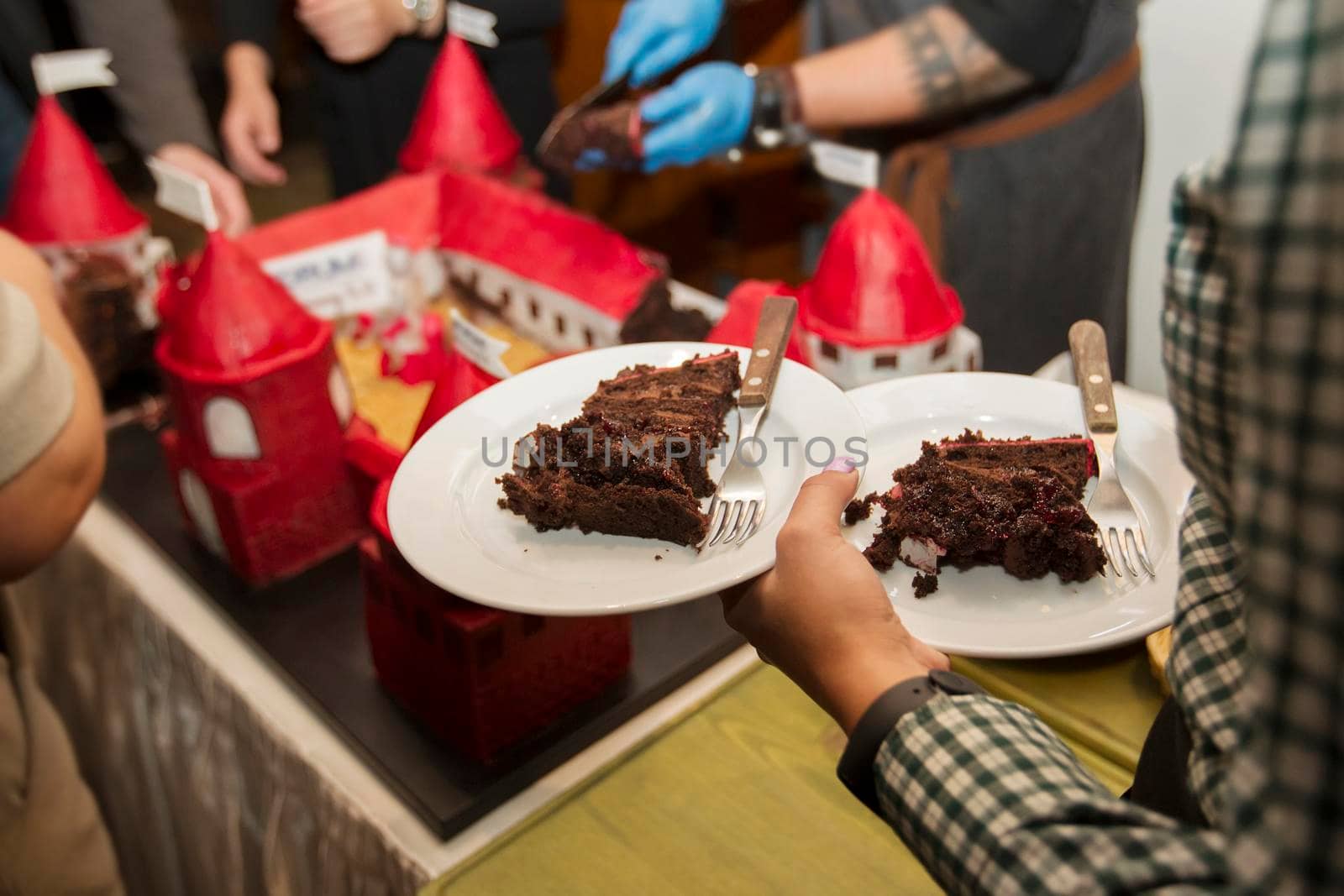 Hands hold a piece of cake on a plate.