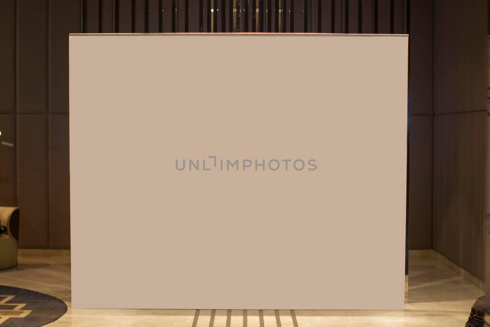A blank white advertising banner stands in the lobby of the room.