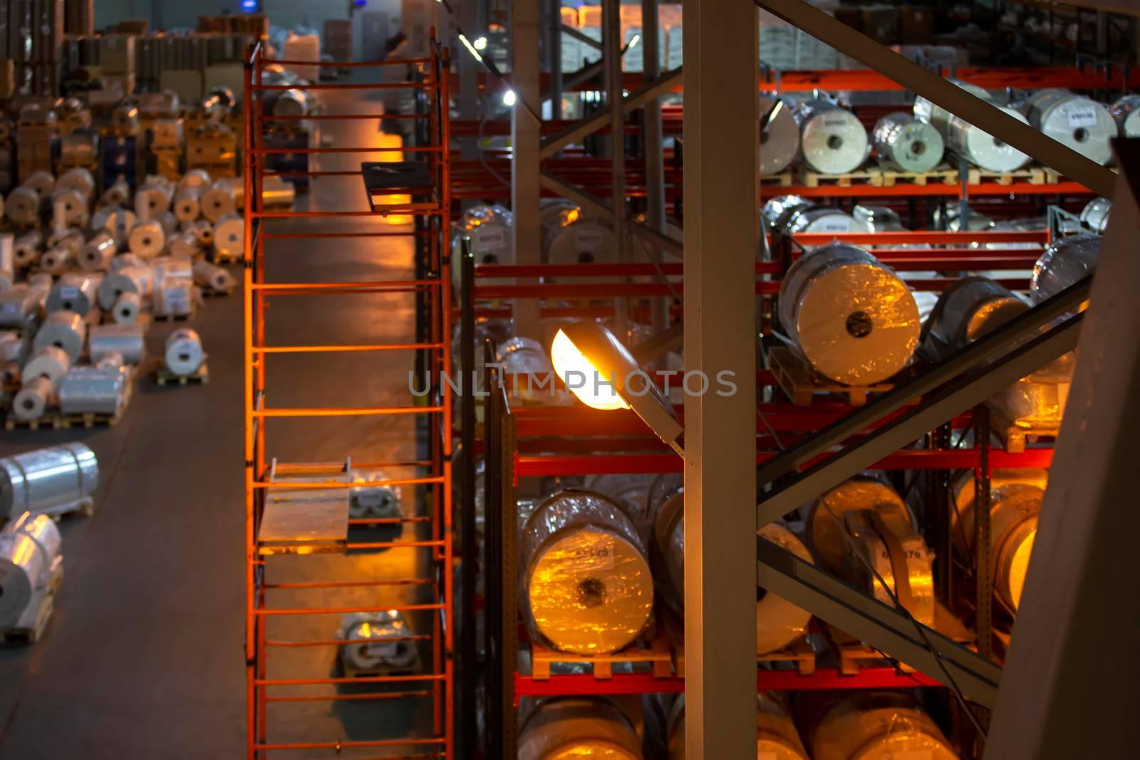 Industrial warehouse with metal shelves and paper rolls. Pulp industry.