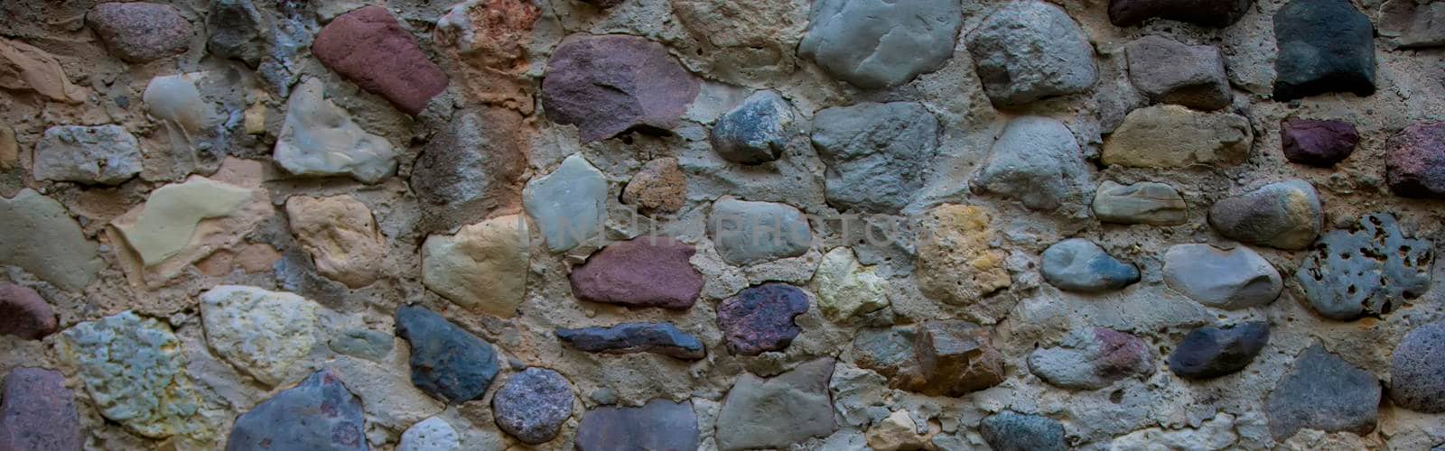 Banner wall from multi-colored large stones boulders.