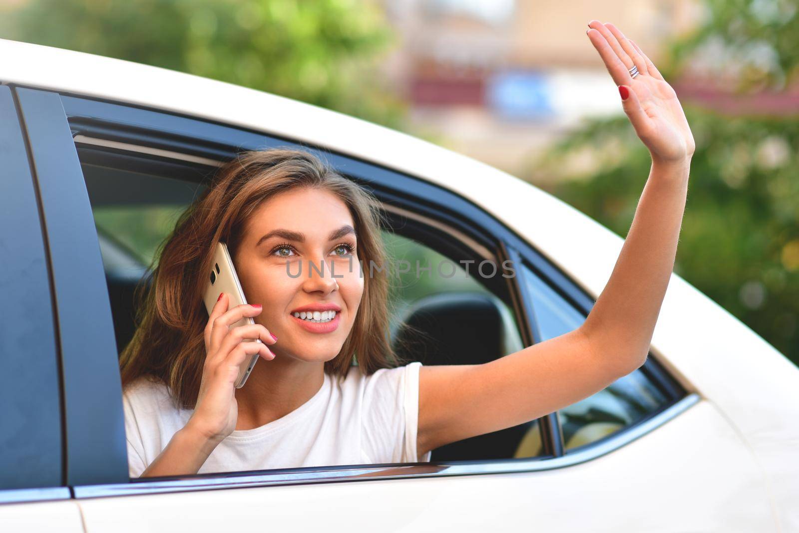 Woman peeking out of car window, woman peeking out of window and waving her hand