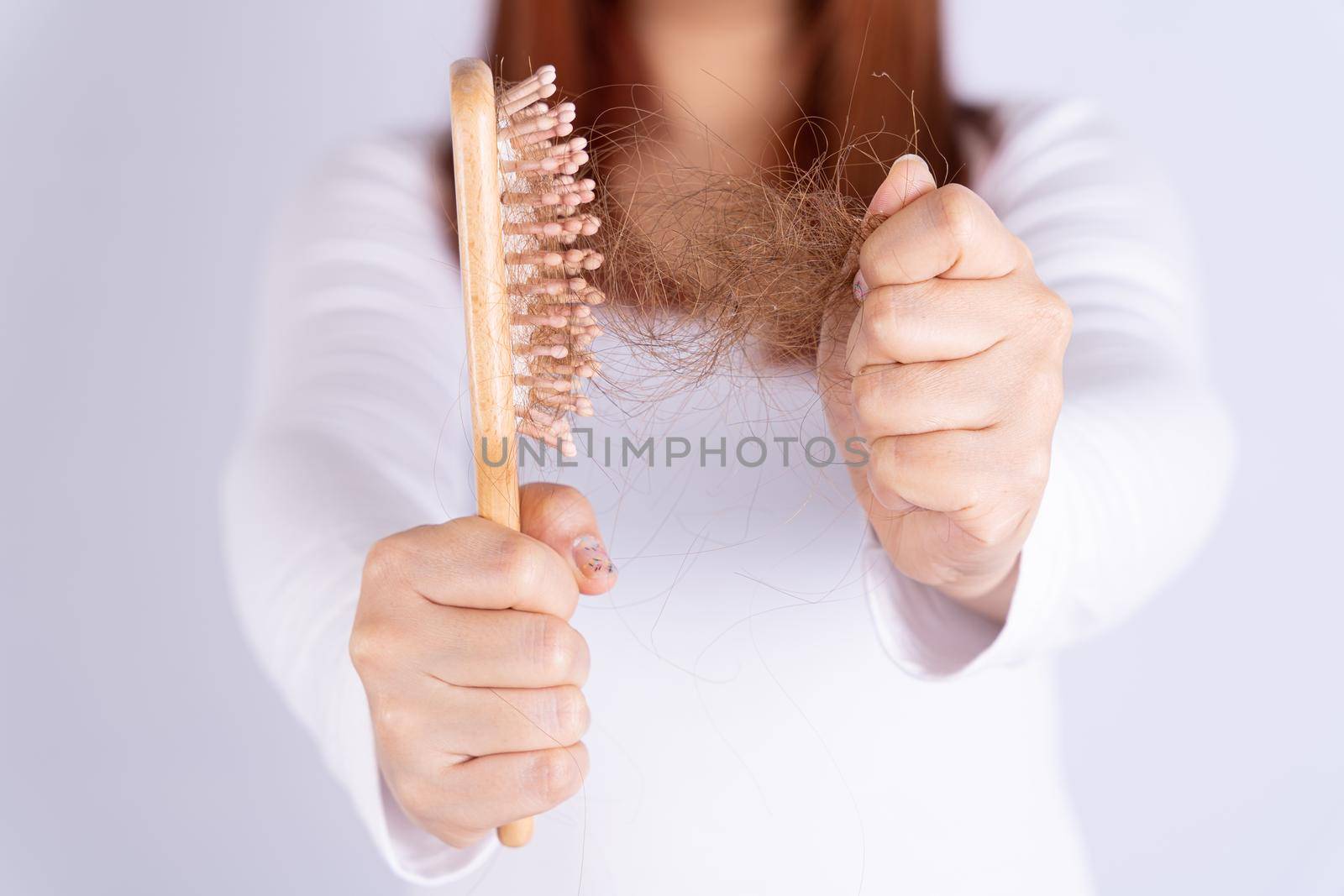 Hair fall problem, closeup hand holding comb and problem hair. Healthcare medical or daily life concept. by mikesaran