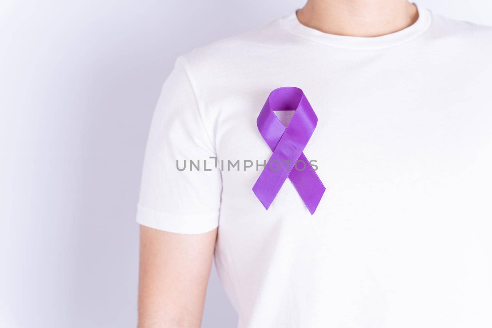 World cancer day, purple ribbon on chest isolated grey background. Healthcare and medical concept. by mikesaran