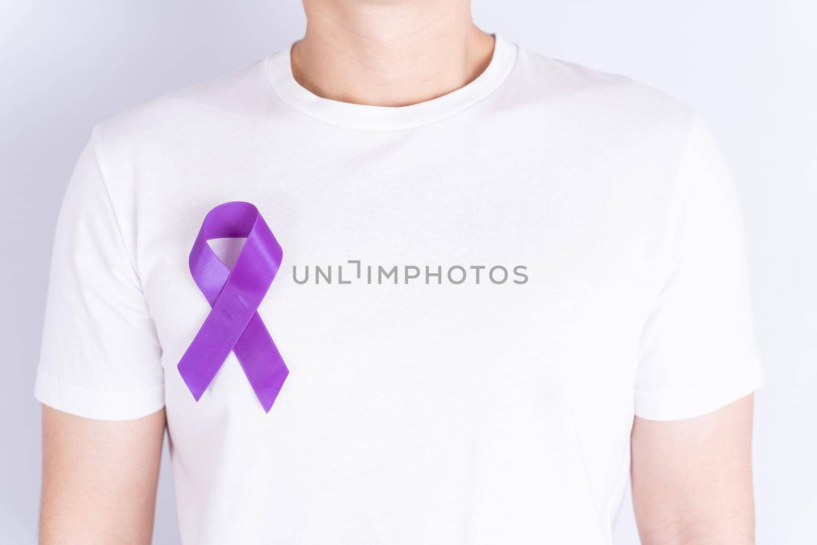 World cancer day, purple ribbon on chest isolated grey background. Healthcare and medical concept. by mikesaran