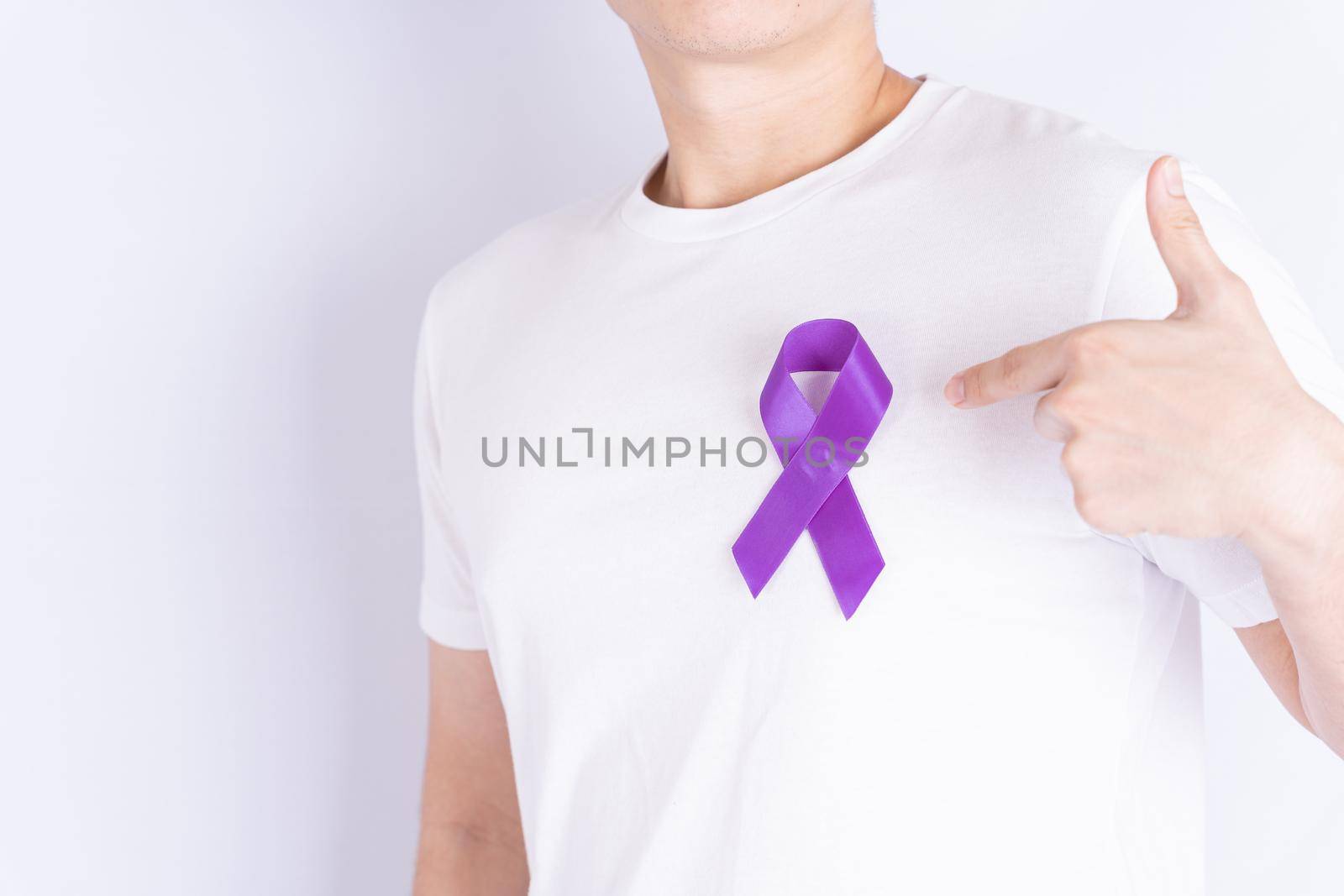 World cancer day, purple ribbon on chest isolated grey background. Healthcare and medical concept.