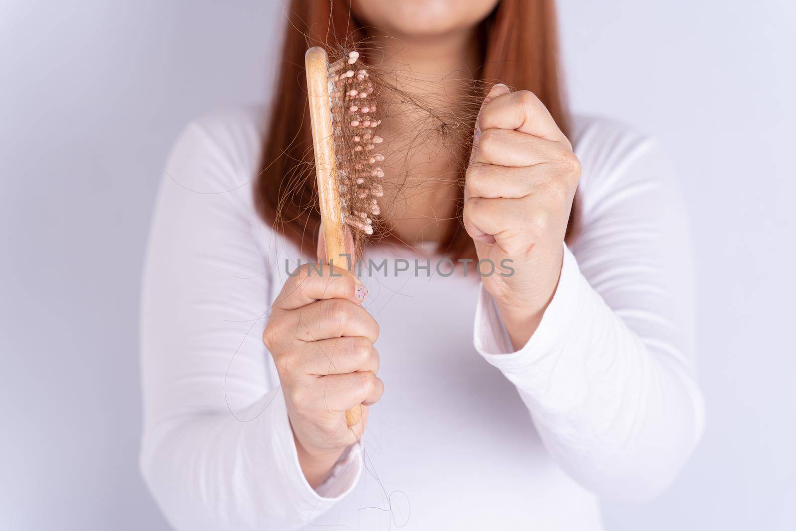 Hair fall problem, closeup hand holding comb and problem hair. Healthcare medical or daily life concept. by mikesaran