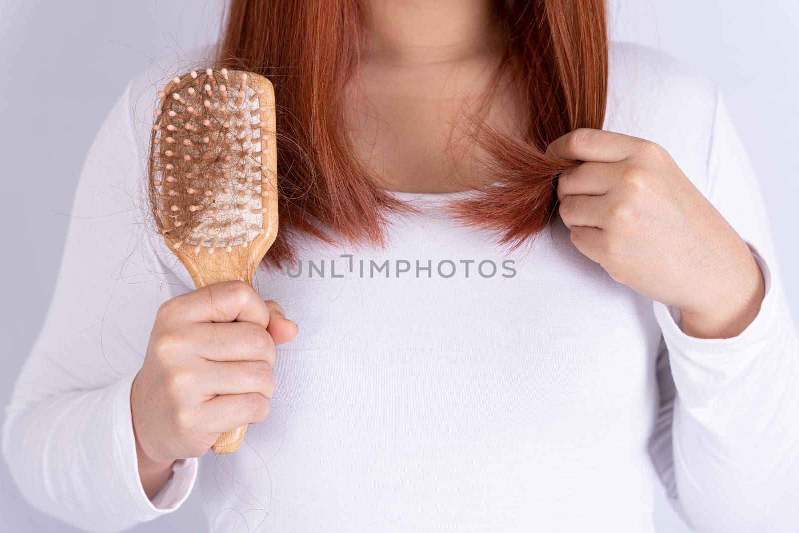 Hair fall problem, closeup hand holding comb and problem hair. Healthcare medical or daily life concept. by mikesaran