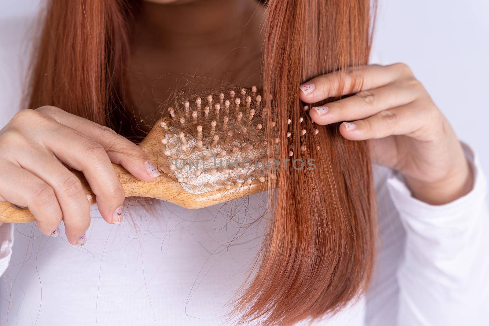 Hair fall problem, closeup hand holding comb and problem hair. Healthcare medical or daily life concept. by mikesaran