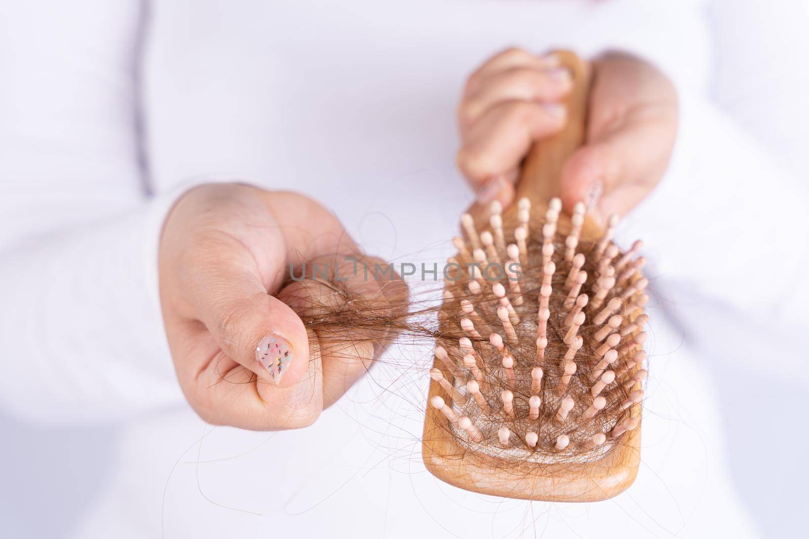 Hair fall problem, closeup hand holding comb and problem hair. Healthcare medical or daily life concept. by mikesaran