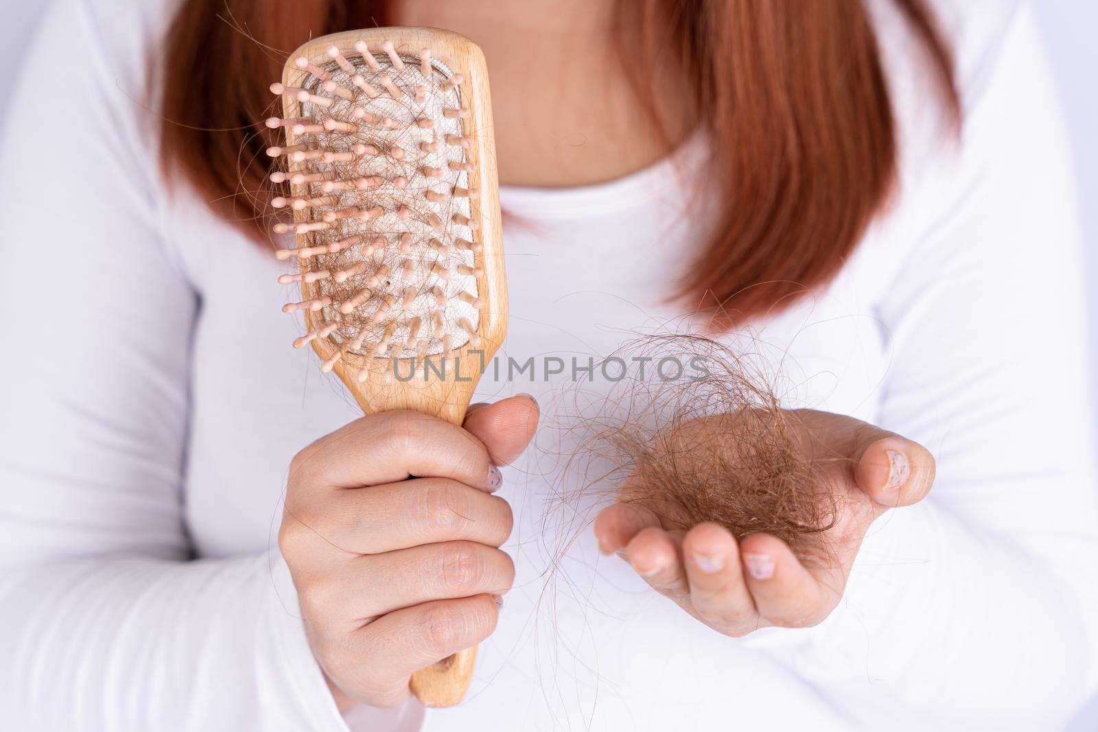 Hair fall problem, closeup hand holding comb and problem hair. Healthcare medical or daily life concept. by mikesaran