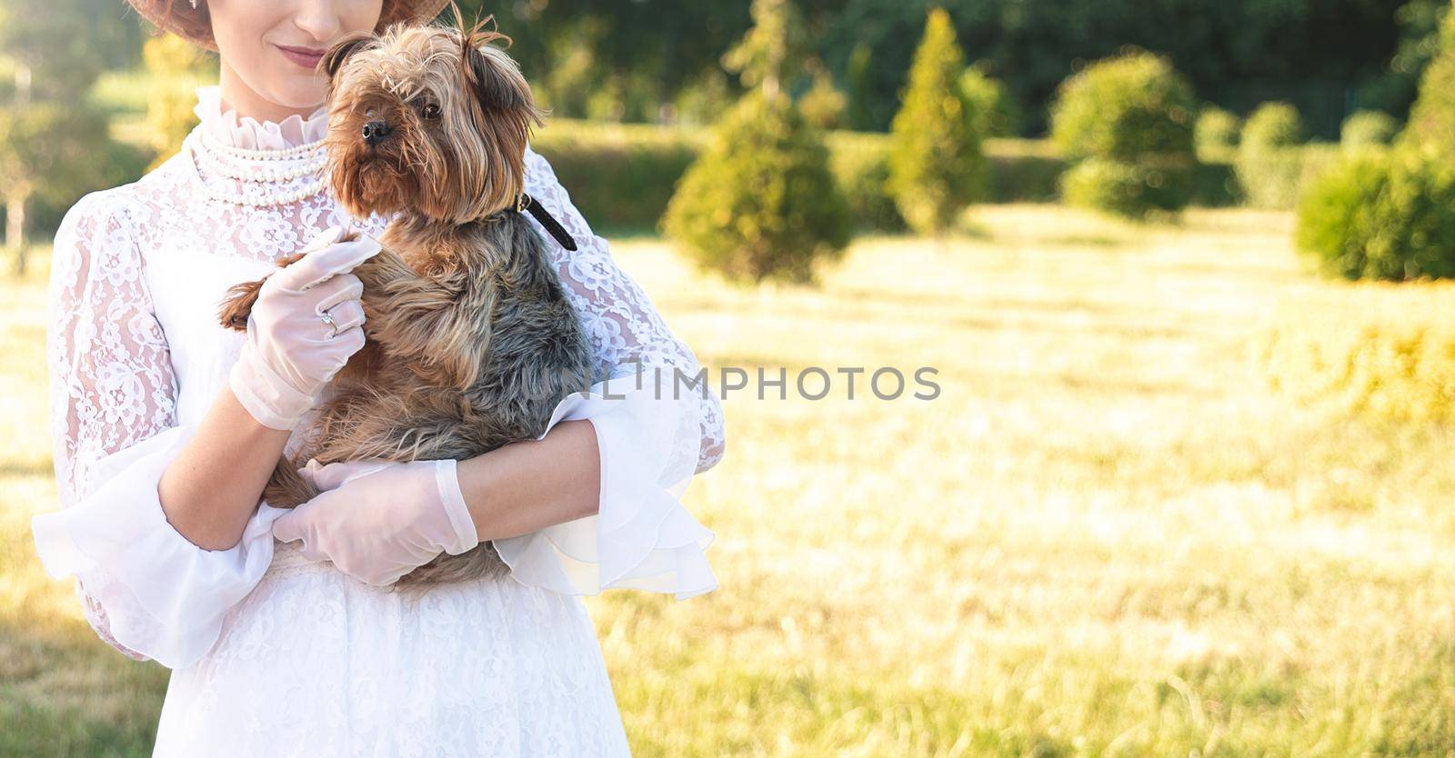 Retro portrait of a beautiful woman holding Yorkshire terrier by Nickstock