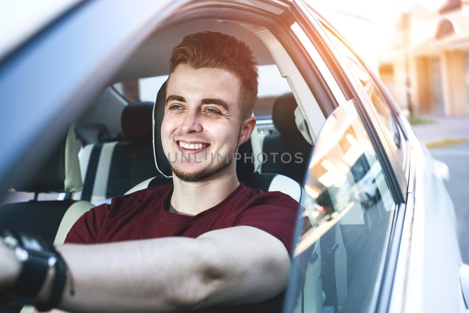 Close up side portrait of happy caucasian man driving car. by Nickstock