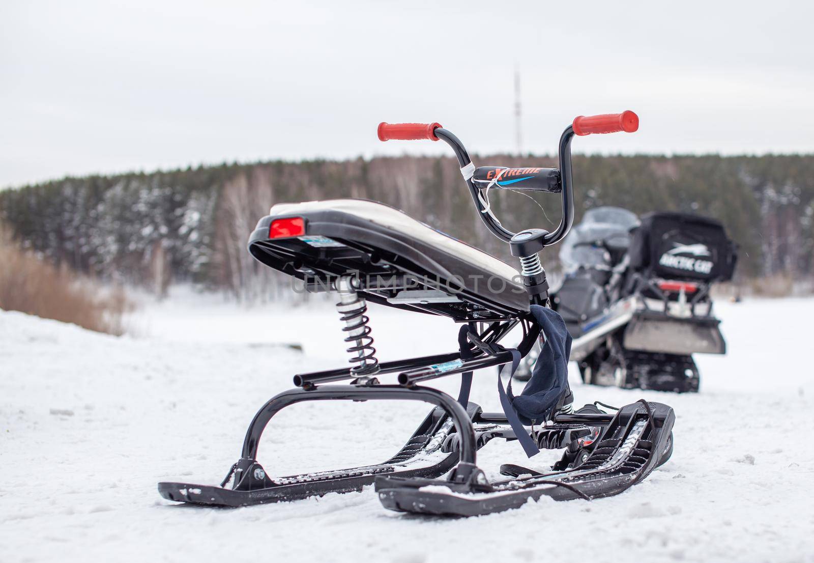 A children's snowmobile is ready for children to ride in the snow by AnatoliiFoto