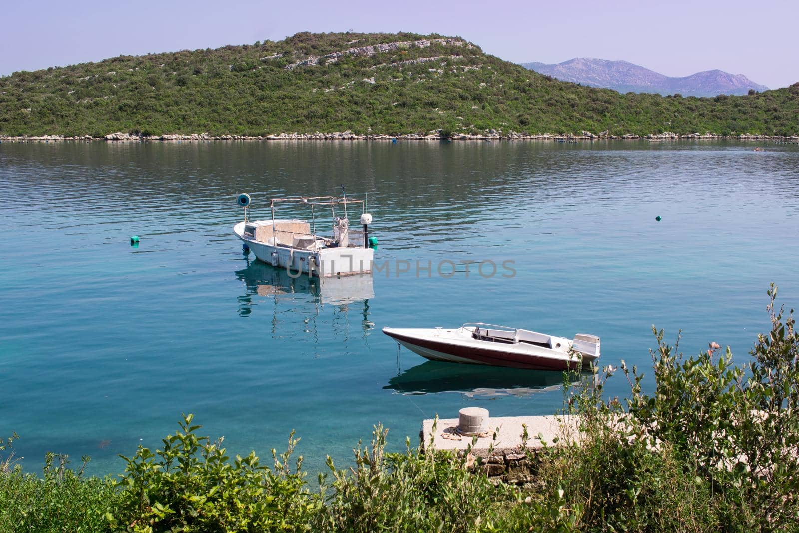 Two fishing boats in calm waters of Mediterranean Adriatic sea in Croatia by VeraVerano