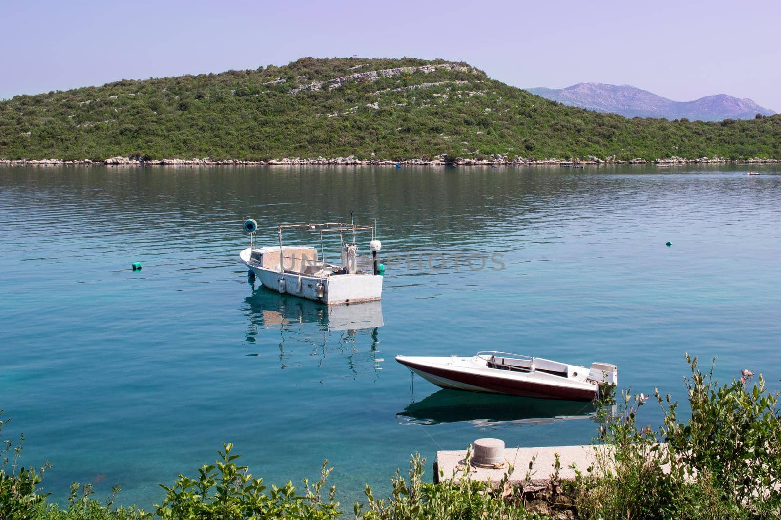 Two small fishing boats in calm waters of Mediterranean Adriatic sea in Croatia by VeraVerano