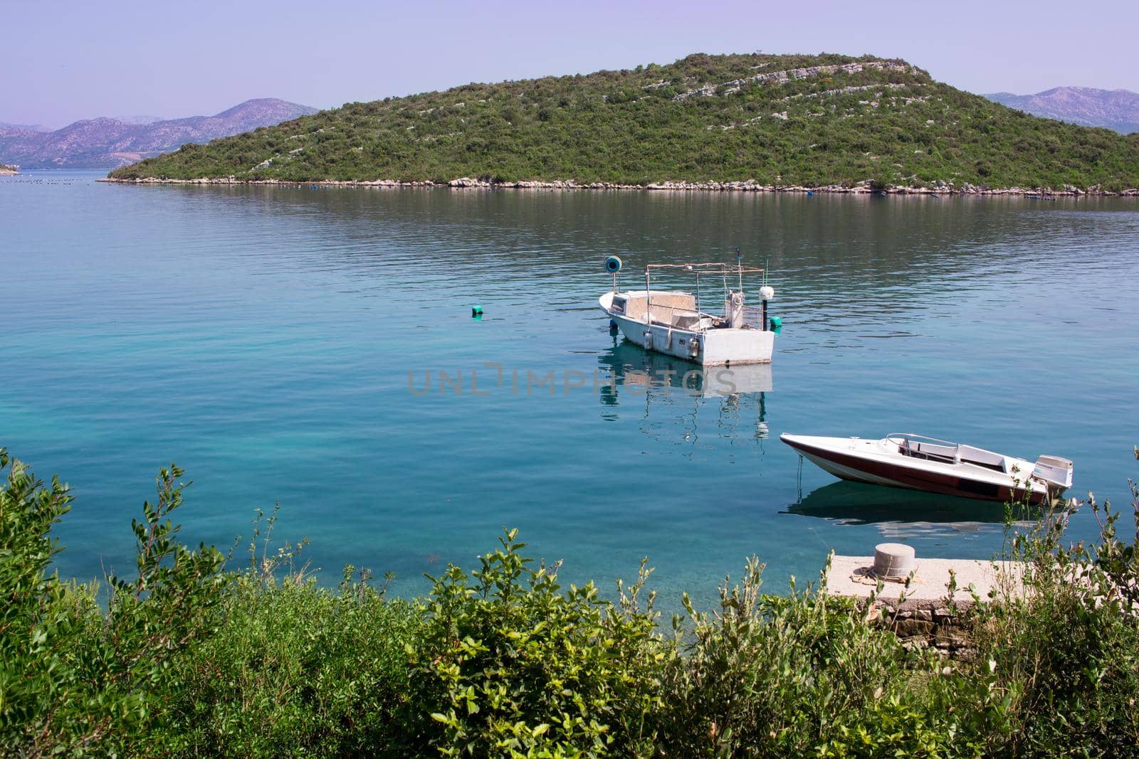 Two small fishing boats in calm waters of Mediterranean sea in Croatia